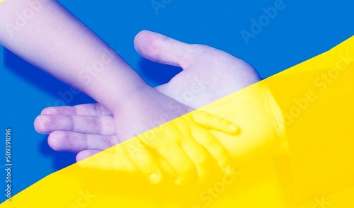 Hand holds hand on Ukraine yellow-blue flag background