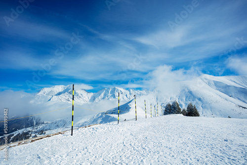 Ski track start on top of a mountain over summits in clouds © Sergey Novikov