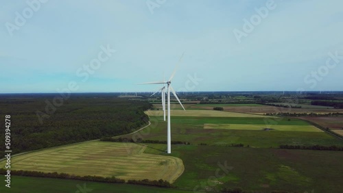 Drone is passing by windfarm in northern germany with multiple mills in a row