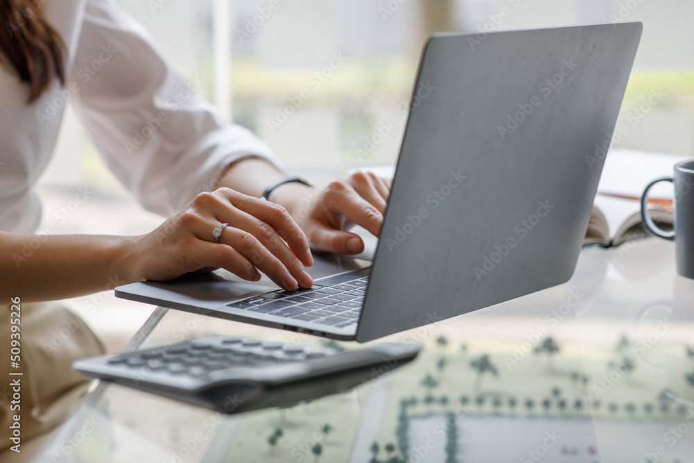 Close up of businesswoman Accounting using calculating income-expenditure and analyzing real estate investment data report Financial and tax systems concept. Close up of businesswoman Accounting using calculating income-expenditure and analyzing real estate investment data report Financial and tax systems concept.