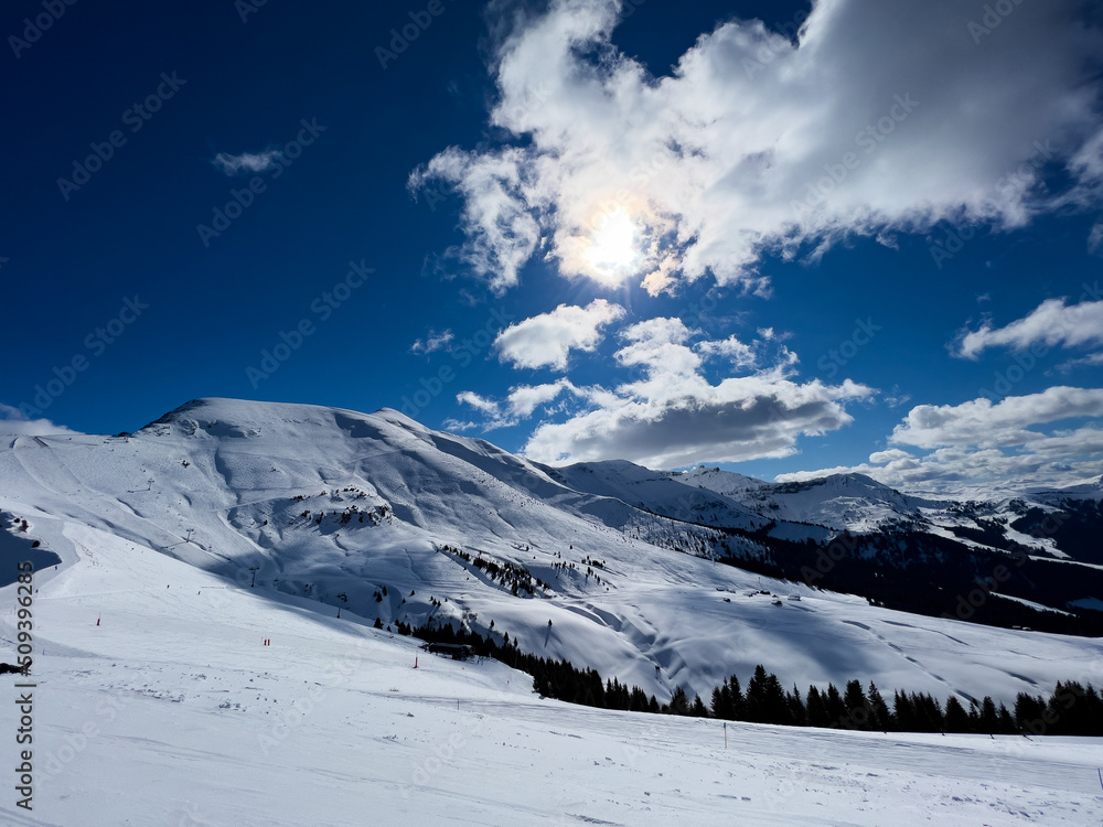 Panorama of alpine ski tracks and mountain tops high in the Alps