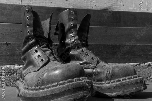 Fototapete a pair of old dusty leather punk boots without laces, closeup black and white ph