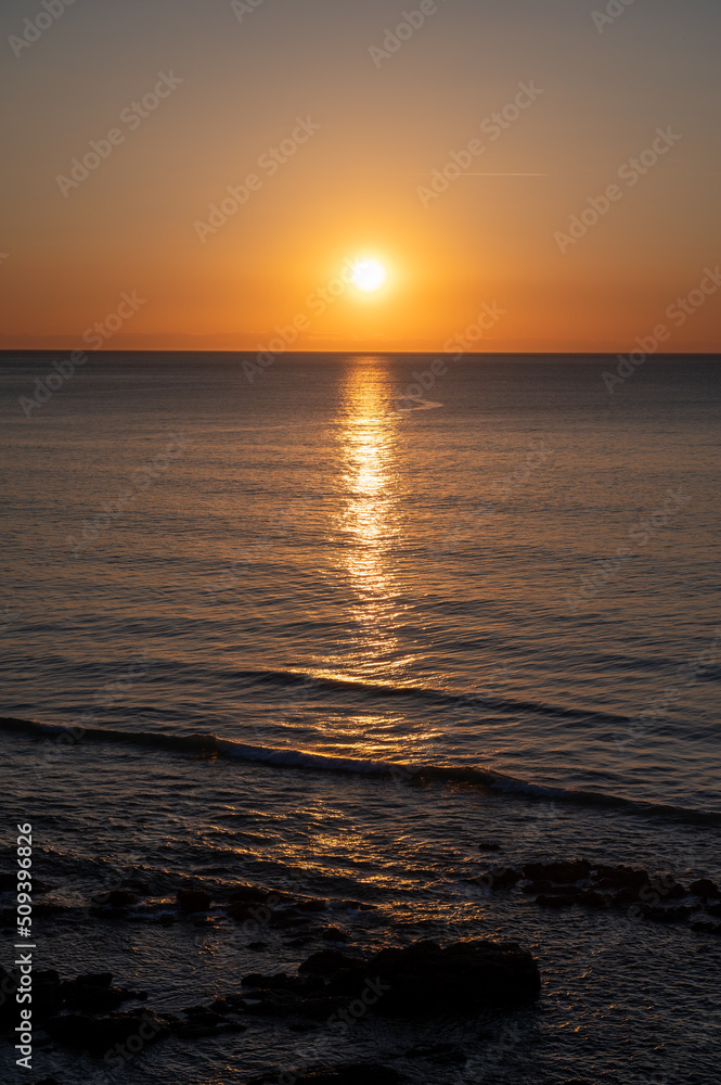 Fototapeta premium Sunset in calm waters of Atlantic ocean and clear sky