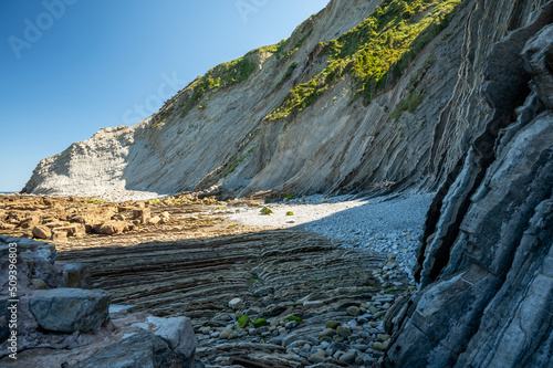 View on steeply-tilted layers of flysch on Atlantic coast at Zumaia at low tide, Basque Country, Spain