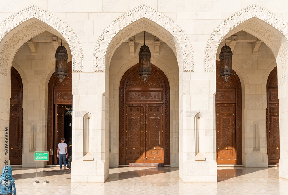 Arched gates and carved wooden doors leading to the Sultan Qaboos Grand Mosque, Oman, Middle East