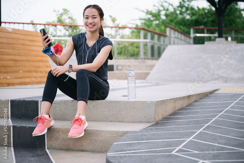 Portrait beautiful Asia woman smart phone after exercise jogging	
