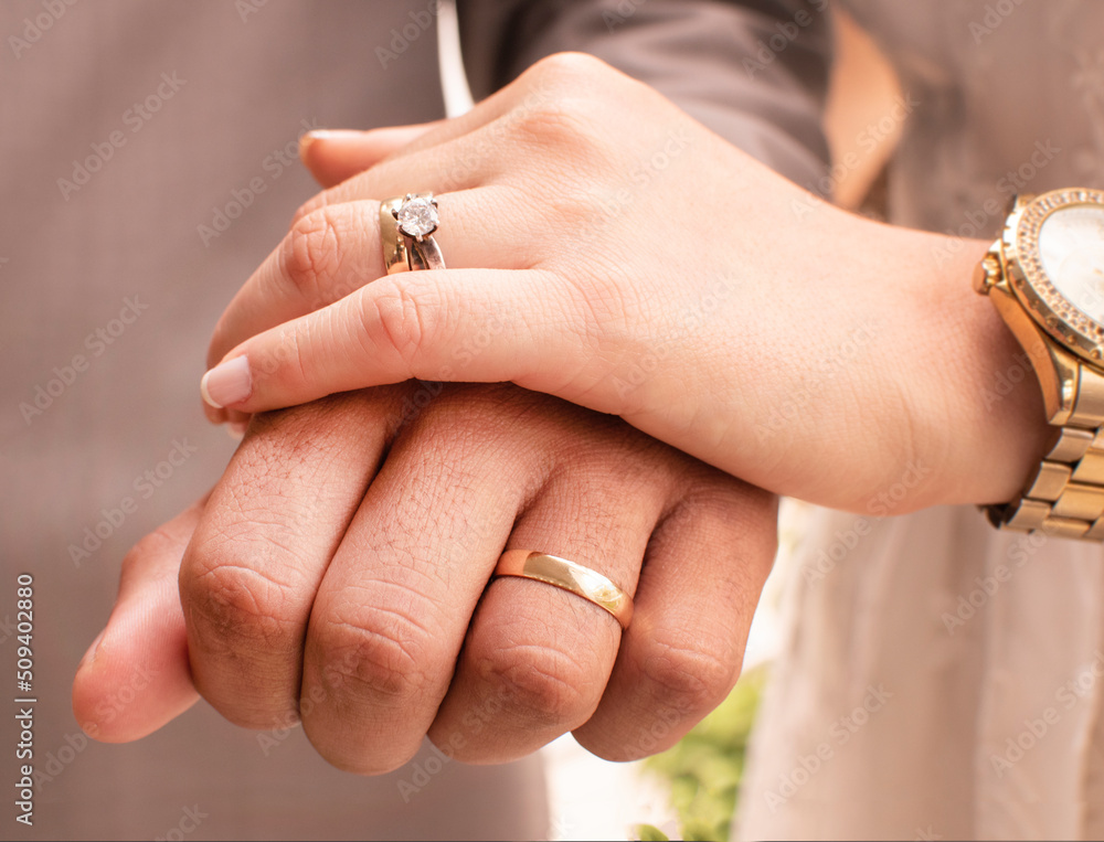 wearing wedding rings, young newlyweds.