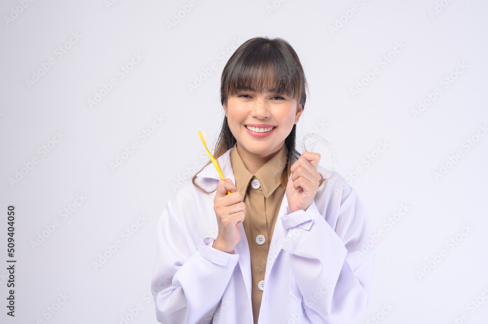 Young female dentist smiling over white background studio Young female dentist smiling over white background studio