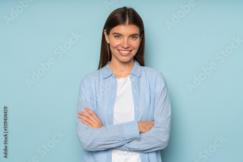 Positive confident businesswoman standing against studio background with crossed Fototapet