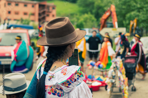 Ecuadorian indigenous men and women dressed in their typical costumes celebrate the cult of the sun god, Inti Raymi, surrounded by fruit and typical food.