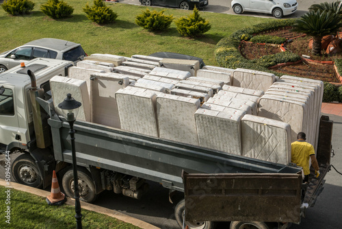 Alte gebrauchte Matratzen werden auf einen Lastwagen geladen