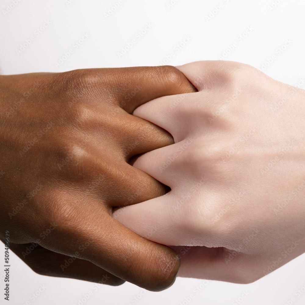 Finger grip. Closeup female hands and fingers holding each other isolated on grey studio background. Concept of diversity, unity, love, support Finger grip. Closeup female hands and fingers holding each other isolated on grey studio background. Concept of diversity, unity, love, support