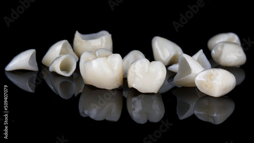 composition of dental crowns and veneers on black glass with reflection