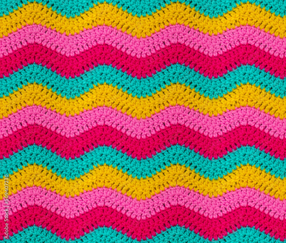 Seamless knitted pattern in the form of zigzags is crocheted with bright multi-colored threads. Acrylic baby yarn. African style. Seamless knitted pattern in the form of zigzags is crocheted with bright multi-colored threads. Acrylic baby yarn. African style.