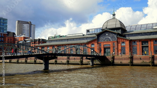 Brücke zur alten Fischauktionshalle in Hamburg - Altona an der Elbe unter weißen Wolken photo