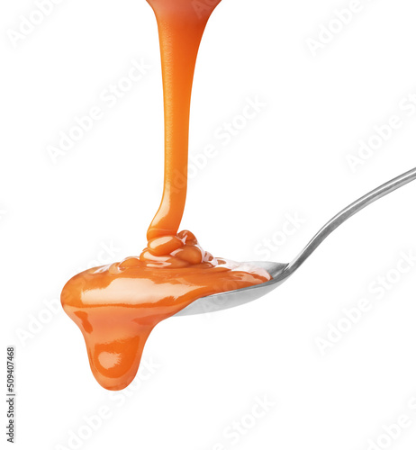 drip of caramel in a spoon on a white background
