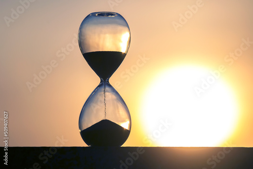 Hourglass on the background of a sunset. The value of time in life. An eternity.
