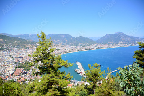 Alanya town with seaport, lighthouse and mountains, view from top