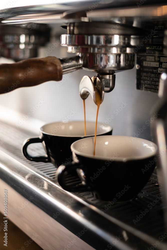 Two cups of coffee being poured from a espresso machine. Two cups of coffee being poured from a espresso machine.