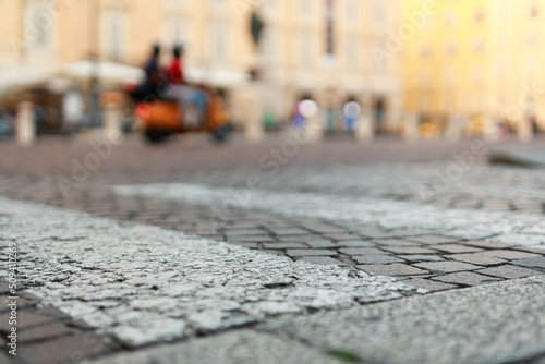 Stone pavement in perspective. Old street paved with stone blocks with white lines. Shallow depth of field. Vintage grunge texture. City ​​and people on background. © KDdesignphoto