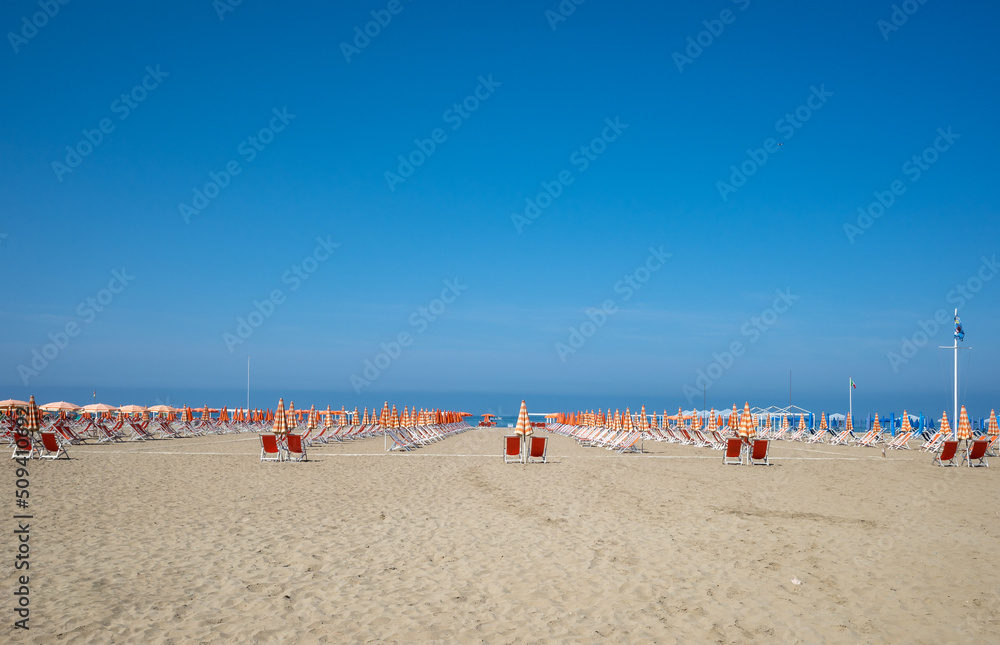 Sandy beach with red deck chairs