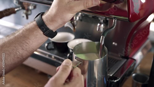 barista frothing milk in a coffee machine