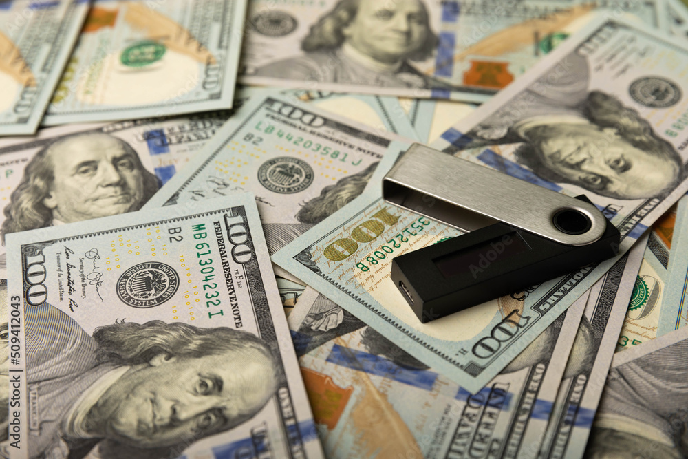 Cryptocurrency cold wallet and one hundred dollar banknotes.Business concept.Currency saving. Investment.Cryptocurrency.Bitcoin digital currency.Crypto coin currency storage business concept. Cryptocurrency cold wallet and one hundred dollar banknotes.Business concept.Currency saving. Investment.Cryptocurrency.Bitcoin digital currency.Crypto coin currency storage business concept.