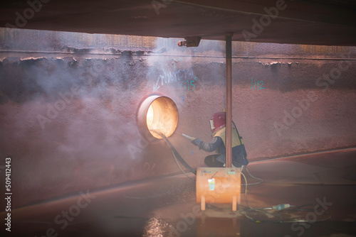 Fotografia, Obraz Male worker surface corrosion plate preparation by sand blasting of tank interna