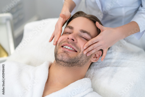 Young man having face massage in a beauty salon