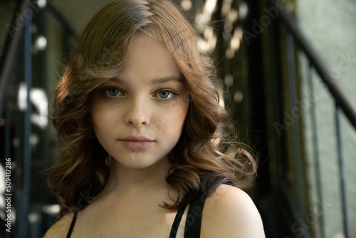 Wallpaper Mural Pretty teen girl with curly hair smiles and looks to the camera. Portrait of beautiful young teenager little girl with nice hairstyle. Close-up, selective focus Torontodigital.ca