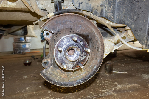 Vehicle disc brake for repair, in the process of replacing new tires. Repair of car brakes in the garage.