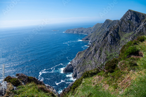 Stunning nature scene of Achill island, county Mayo, Ireland. Green hills and blue sky and ocean surface. Irish landscape. Warm sunny day. Popular travel area.