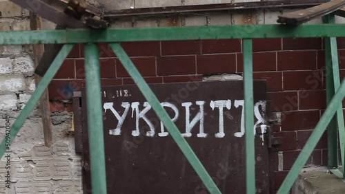 The inscription in Ukrainian language on the doors - shelter. Entrance to the bomb-shelter. Russian Invasion of Ukraine. photo