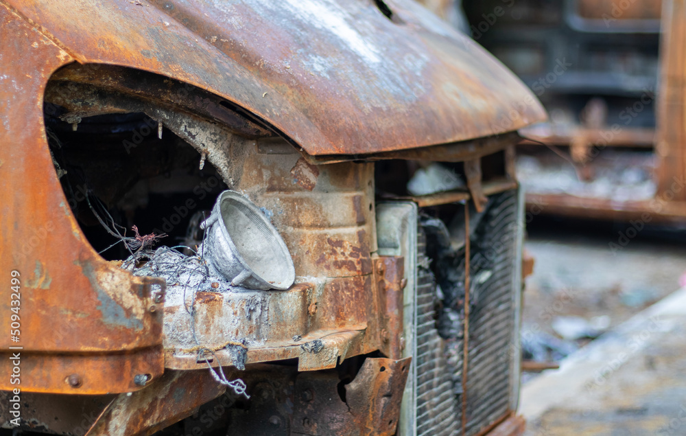 The car was completely destroyed by fire. Abandoned, burnt and rusty car by the road. Cars were on fire in the parking lot. War of Russia against Ukraine. Shrapnel and bullet holes in cars. The car was completely destroyed by fire. Abandoned, burnt and rusty car by the road. Cars were on fire in the parking lot. War of Russia against Ukraine. Shrapnel and bullet holes in cars.