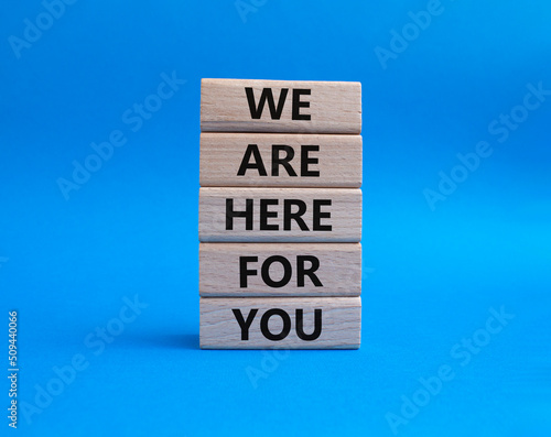 Help symbol. Wooden blocks with words 'We are here for you'. Beautiful blue background. Business and 'We are here for you' concept. Copy space.