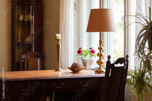 Beautiful vintage dining table with candles and window coverings. © Edite