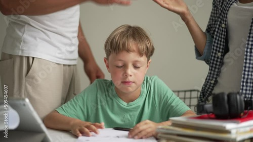 Father helping his son with schoolwork. Young little shoolboy solving mathematics homework with his family photo