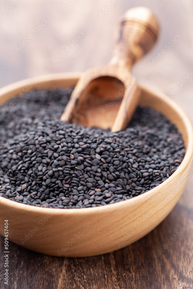Bio natural black sesame seeds on wooden bowl. Bio natural black sesame seeds on wooden bowl.