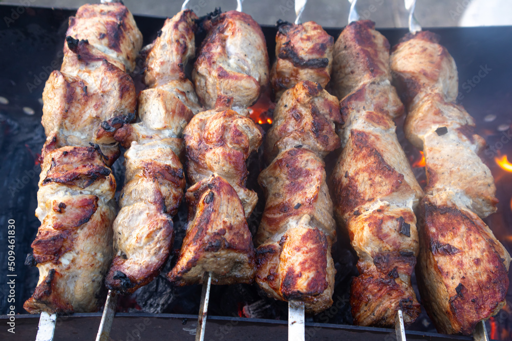 pork shish kebab, fried on skewers, roasted on the grill, on charcoal. party and juicy meat. The concept of lunch, dinner, restaurant, guests, holiday. High quality photo