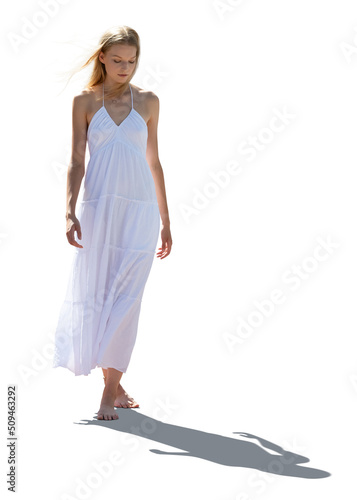 Canvas Print Backlit photo of a young woman in a long summer dress walking barefoot with wind