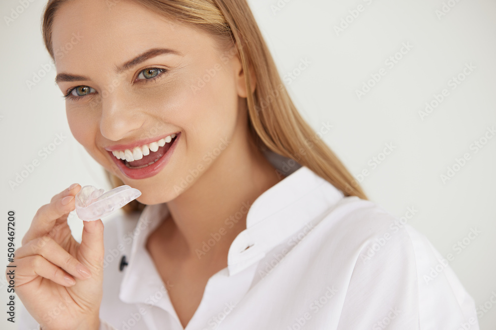 Teeth Whitening. Woman with White Smile, Using Removable Braces. Closeup Of Beautiful Happy Smiling Woman Holding Whitening Tray, Invisible Braces, Teeth Trainer. Dental Treatment, Health Concept Teeth Whitening. Woman with White Smile, Using Removable Braces. Closeup Of Beautiful Happy Smiling Woman Holding Whitening Tray, Invisible Braces, Teeth Trainer. Dental Treatment, Health Concept