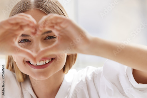 Healthy Eyes And Vision. Woman Holding Heart Shaped Hands Near Eyes. Portrait Of Beautiful Happy Girl With Healthy Skin Showing Love Sign. Eye care. High Resolution Image photo