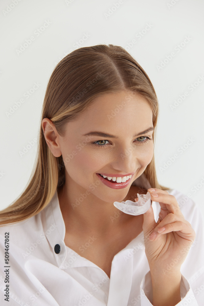 Teeth Whitening. Woman with White Smile, Using Removable Braces. Girl Using Teeth Whitening Tray, Holding Invisible Braces. Dental Treatment Concept. High Resolution Image Teeth Whitening. Woman with White Smile, Using Removable Braces. Girl Using Teeth Whitening Tray, Holding Invisible Braces. Dental Treatment Concept. High Resolution Image