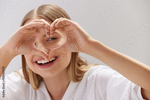 Healthy Eyes And Vision. Woman Holding Heart Shaped Hands Near Eyes. Portrait Of Beautiful Happy Girl With Healthy Skin Showing Love Sign. Eye care photo
