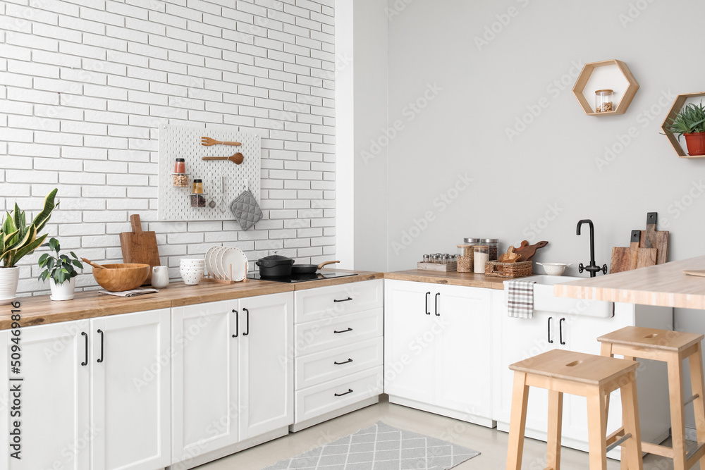 Interior of light kitchen with counters, utensils and stools Interior of light kitchen with counters, utensils and stools
