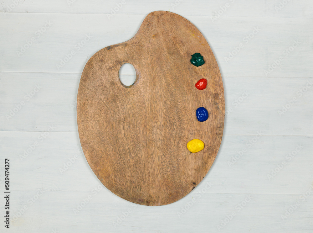 Paints on a round wooden palette. Top view on a gray wooden background Paints on a round wooden palette. Top view on a gray wooden background