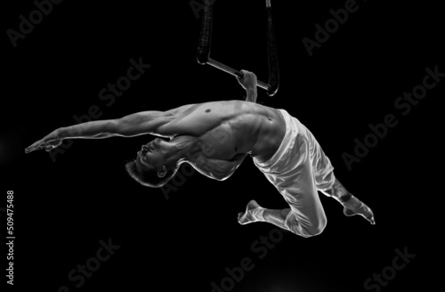 Muscular male air circus artist performances with dance trapeze 