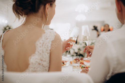 beautiful bride and groom sitting on a table with a wedding rings