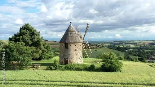 moulin à vent et champ de blé surplombant la campagne française	 photo
