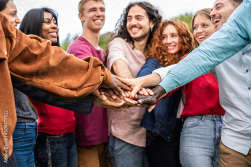 Multiracial happy young people stacking hands outdoor -  Group of volunteer having fun in the park